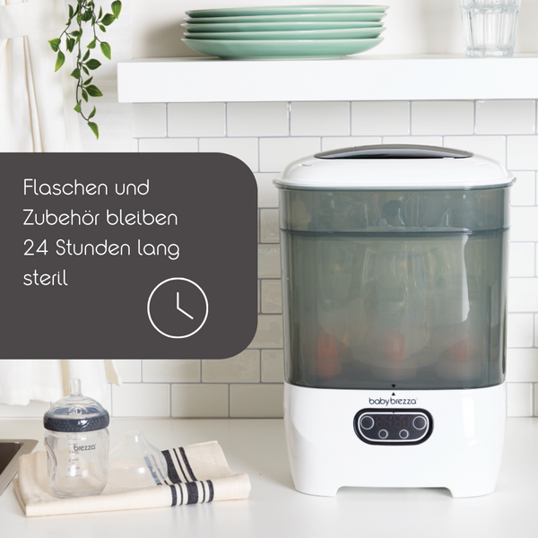Der „Sterilizer Dryer Advanced“ von Babybrezza.de mit 4-in-1-Funktionalität steht neben einer sterilisierten Flasche auf der Küchentheke. Der deutsche Text lautet: „Flaschen und Zubehör bleiben 24 Stunden lang steril“, was bedeutet, dass Flaschen und Zubehör 24 Stunden lang steril bleiben. - product thumbnail