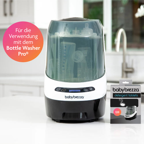 Ein Tischgerät mit der Aufschrift „Baby Brezza“ fasst mehrere Babyflaschen neben einer Schachtel Babybrezza.de Bottle Washer Pro Reinigungstabletten – 120 Stück. Ein rosafarbener Kreis markiert: „Für die Verwendung mit dem Bottle Washer Pro®“ und sorgt so für eine effiziente Babyflaschenreinigung. - product thumbnail