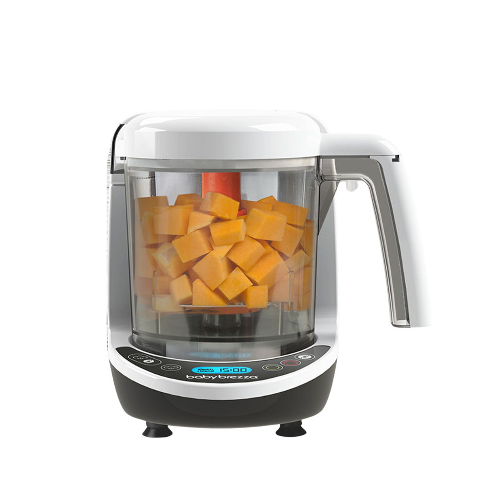 Der weiß-schwarze automatische Baby Brezza.de Food Maker Deluxe: Babynahrungszubereiter, ideal für die Zubereitung von geschnittenem orangefarbenem Gemüse, verfügt über ein digitales Bedienfeld an der Basis, einen Griff auf der rechten Seite und bietet 3-in-1-Funktionalität für vielfältige kulinarische Bedürfnisse.