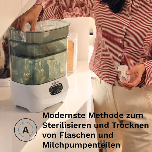 Eine Person legt ein Babyflaschenteil in den Babybrezza.de Sterilizer Dryer Advanced, einen automatischen Babyflaschen-Sterilisator, der im folgenden deutschen Text als moderne Methode zum Sterilisieren und Trocknen von Flaschen und Milchpumpenteilen beschrieben wird. - product thumbnail